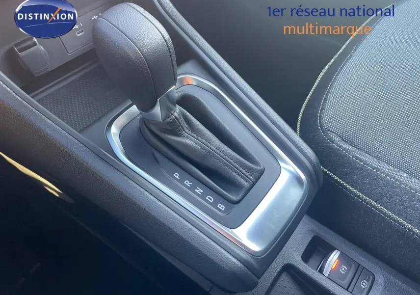 Gros plan sur la console centrale avec levier de vitesse automatique du Renault Captur E-Tech Hybrid 2025, intérieur tissu noir.