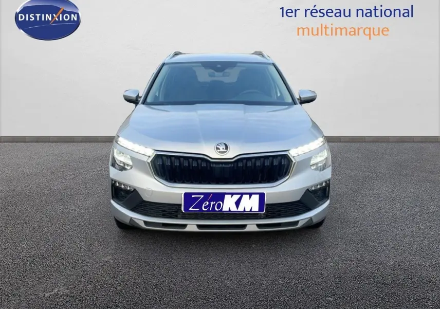 Vue frontale d'un Skoda Kamiq gris argent métallisé avec calandre noire et feux LED allumés.