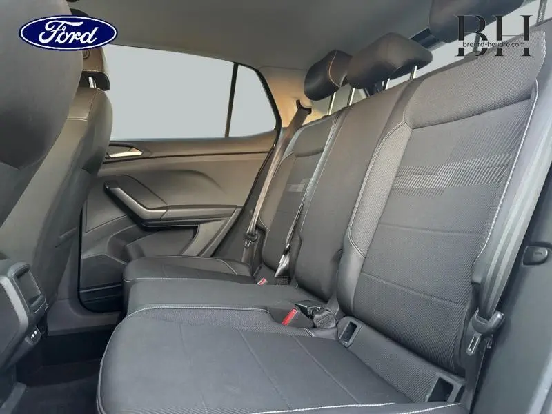 Vue latérale intérieure des sièges arrière noirs du Volkswagen T-Cross 2022, montrant la banquette et les ceintures de sécurité.