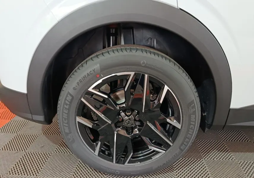 Gros plan sur la roue arrière droite d’un Peugeot 3008 blanc, mettant en valeur la jante noire brillante au design moderne.