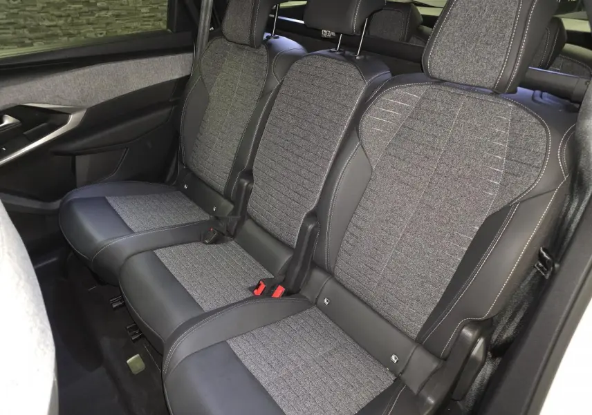 Vue intérieure du siège arrière central en tissu gris et cuir noir du Peugeot 5008 hybride 2025, avec ceinture de sécurité visible.