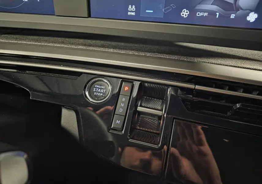 Détail de la console centrale noire brillante du Peugeot 5008 blanc, avec bouton start/stop et sélecteur de boîte automatique.