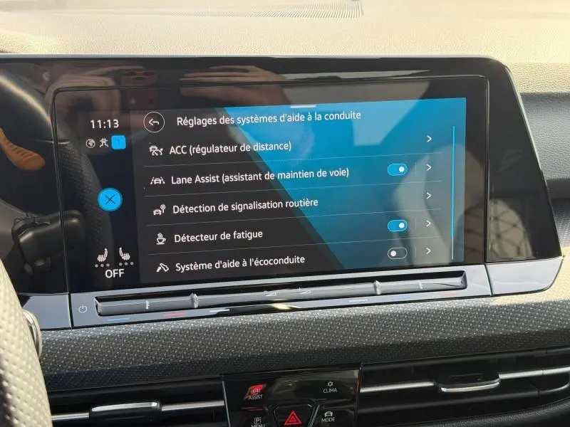 Écran tactile central du tableau de bord de la Volkswagen Golf 1.5 eTSI R-Line 2024 affichant les réglages d’aides à la conduite.