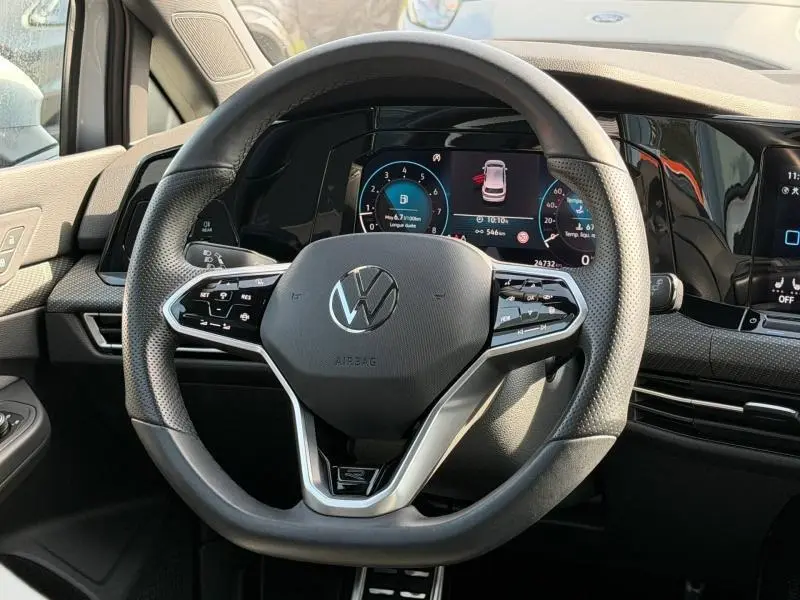 Vue rapprochée du volant multifonction de la Volkswagen Golf 2024 avec tableau de bord numérique et finition R-Line.