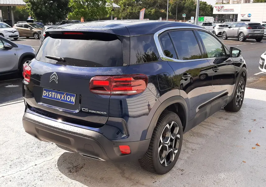 Vue 3/4 arrière droite du Citroën C5 Aircross bleu éclipse, avec jantes bi-ton et vitres arrière teintées.