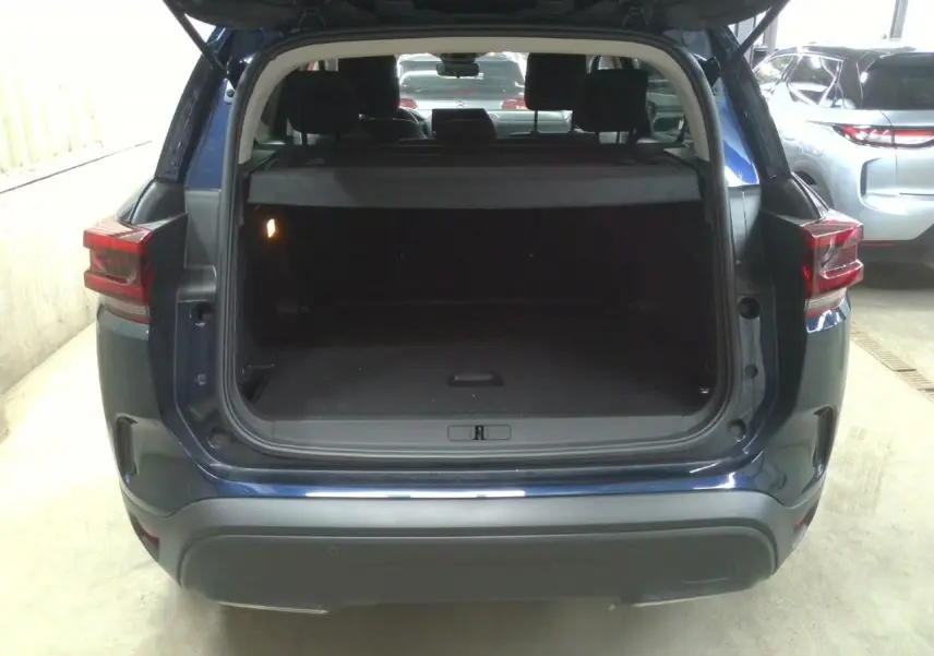 Vue arrière du Citroën C5 Aircross 2025 bleu éclipse avec coffre ouvert montrant l’espace de chargement vide.