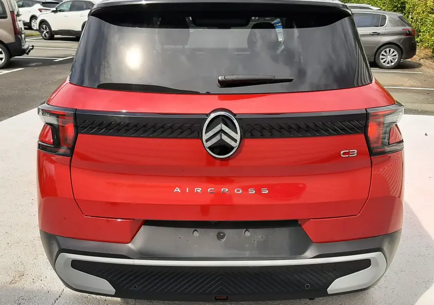 Vue arrière d'un Citroën C3 Aircross rouge Elixir avec toit noir, mettant en valeur son logo et ses feux modernes.