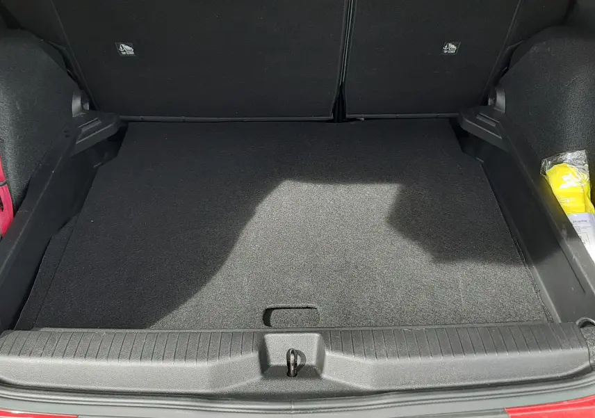 Coffre ouvert d'une Citroën C3 Aircross rouge Elixir avec toit noir, montrant un espace de rangement vide et propre.