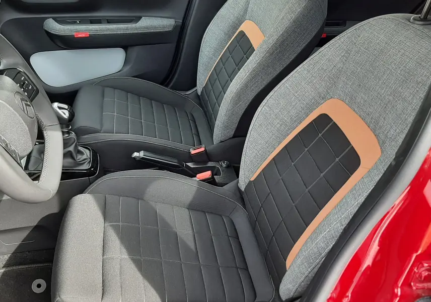 Vue intérieure côté gauche de la Citroën C3 Aircross 2025 rouge Elixir, sièges tissu gris noir avec inserts marron.