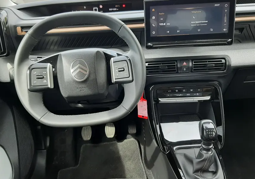 Vue intérieure du poste de conduite de la Citroën C3 Aircross 2025, volant compact et levier de vitesse manuel visibles.