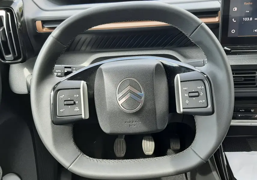 Vue rapprochée du volant carré noir du Citroën C3 Aircross 2025 avec commandes intégrées et tableau de bord numérique.