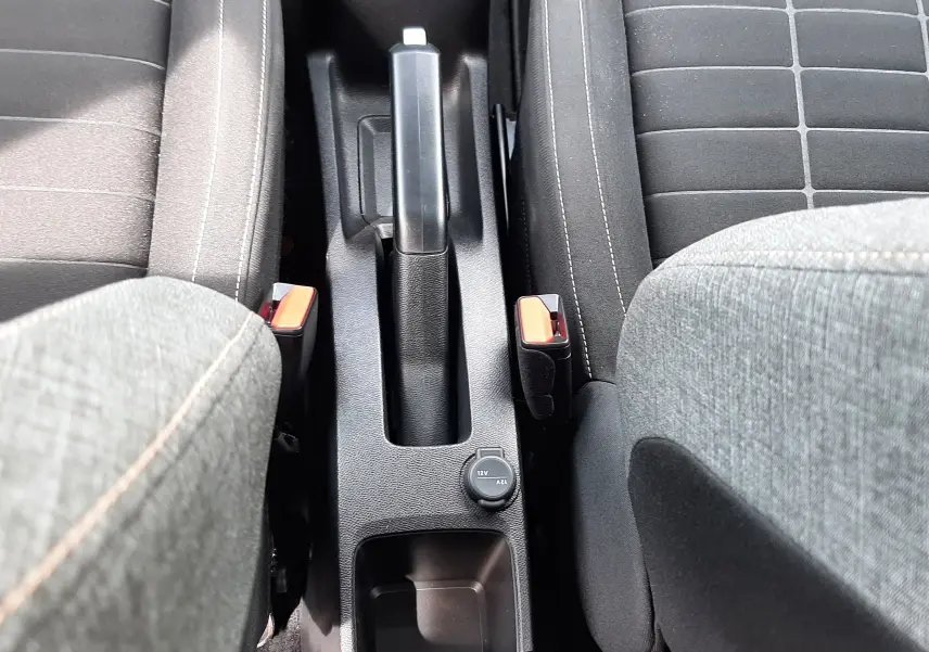 Vue plongeante sur la console centrale noire entre les sièges avant gris foncé du Citroën C3 Aircross 2025.