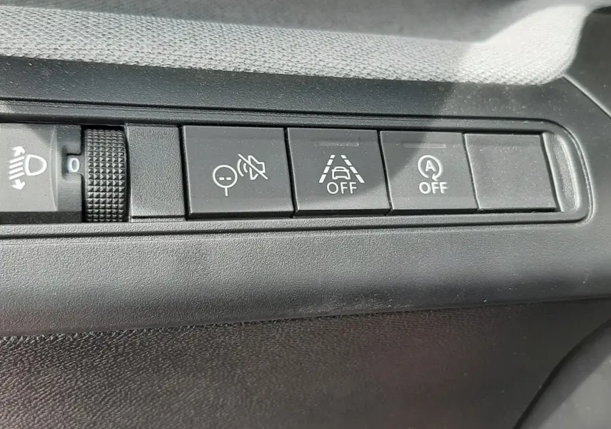 Gros plan sur les boutons de commande intérieurs du tableau de bord de la Citroën C3 Aircross 2025, finition rouge Elixir.