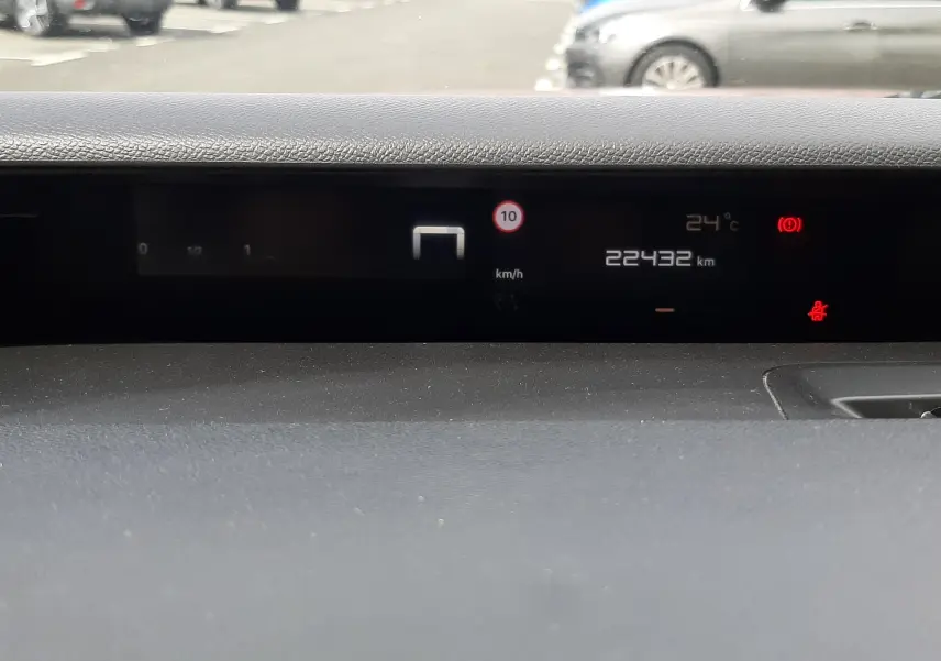 Vue intérieure du tableau de bord numérique de la Citroën C3 Aircross rouge Elixir, affichant la vitesse et la température.