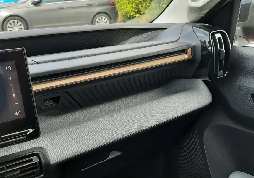 Vue intérieure côté passager du tableau de bord gris et noir du Citroën C3 Aircross 2025 avec écran tactile et aérateurs verticaux.