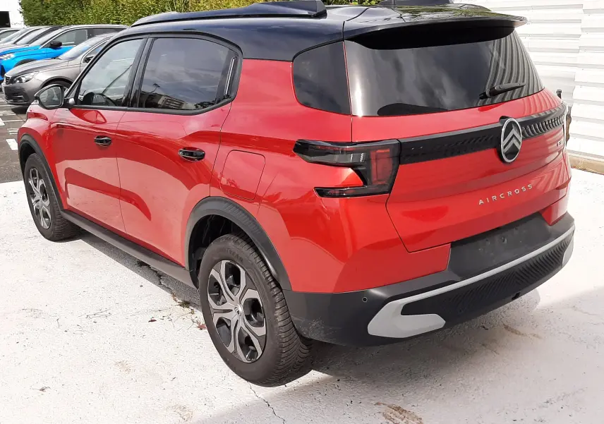 Vue 3/4 arrière droite d'une Citroën C3 Aircross rouge Elixir avec toit noir, feux arrière LED et jantes alliage.