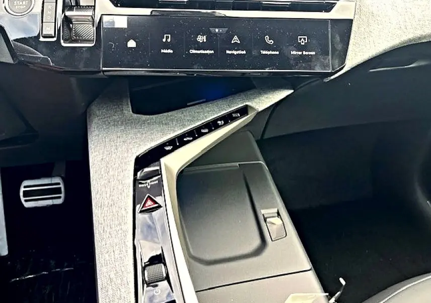 Vue intérieure centrée sur la console centrale grise et noire du Peugeot 3008 hybride avec écran tactile et commandes modernes.