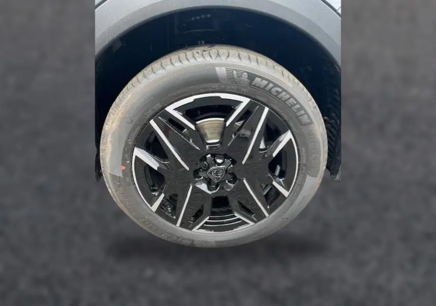 Gros plan sur la roue avant droite du Peugeot 3008 gris titane avec jante alu noire et détails argentés.