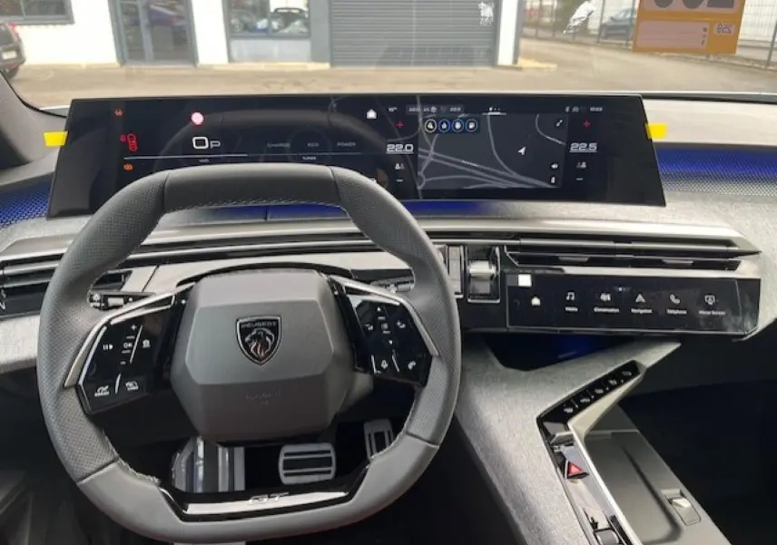 Vue intérieure du poste de conduite du Peugeot 3008 gris titane, avec volant multifonction et écran tactile panoramique.