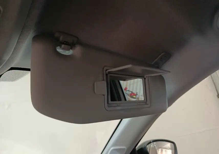 Détail du pare-soleil côté conducteur avec miroir de courtoisie ouvert dans une Peugeot 208 électrique gris clair.