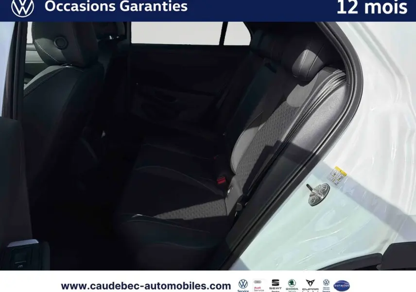 Vue intérieure côté droit des sièges arrière noirs du Volkswagen T-Roc blanc avec porte ouverte.