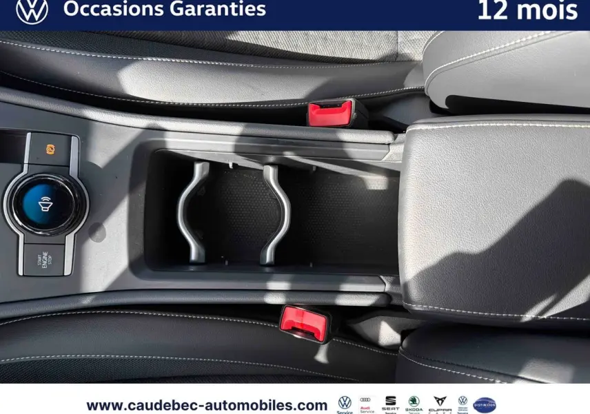 Vue plongeante sur la console centrale noire du Volkswagen T-Roc 2025 avec bouton Start/Stop et porte-gobelets.