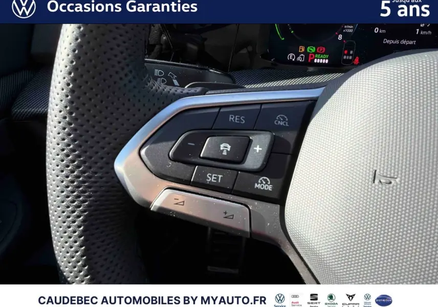 Gros plan sur le volant perforé gris clair de la Volkswagen Golf 1.5 eHybrid 2026 avec commandes intégrées.