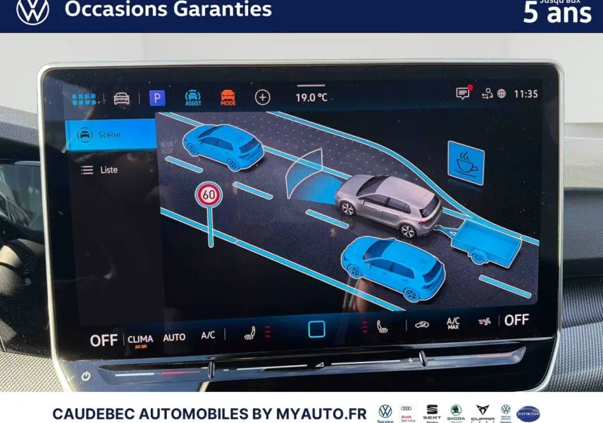 Écran tactile intérieur montrant l'assistance au stationnement d'une Volkswagen Golf blanche vue de dessus avec remorque.