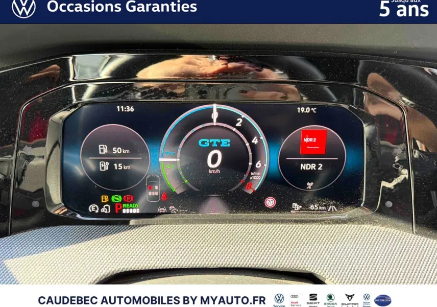 Tableau de bord digital de la Volkswagen Golf 1.5 eHybrid blanche, affichage GTE et informations de conduite.