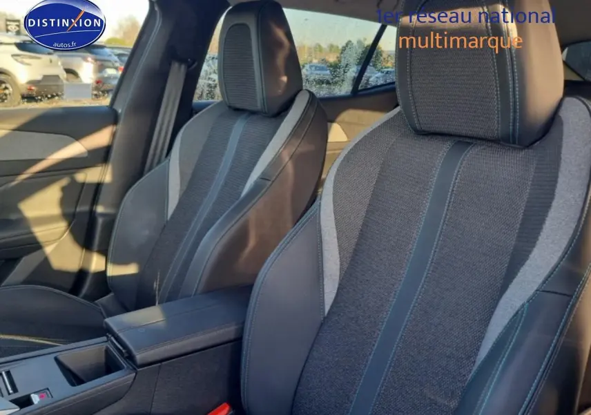 Vue intérieure des sièges avant gris foncé et tissu avec surpiqûres bleues du Peugeot 408 Hybrid 145 allure e-dcs6.