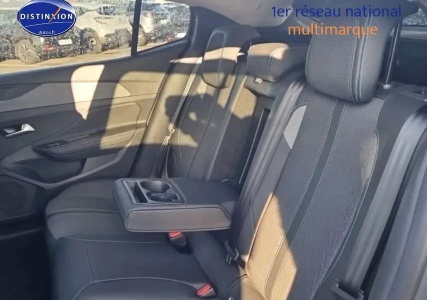 Vue intérieure côté droit de la banquette arrière grise avec accoudoir central et porte-gobelets du Peugeot 408 Hybrid 145 allure 2025.