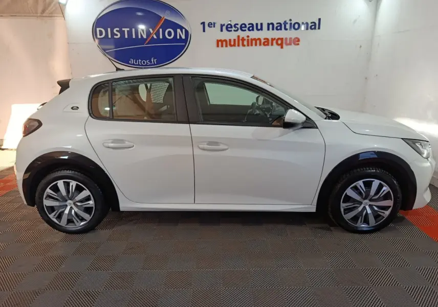 Vue de profil côté gauche d'une Peugeot 208 électrique Active Business blanche, avec jantes stylisées et logo "e" arrière.