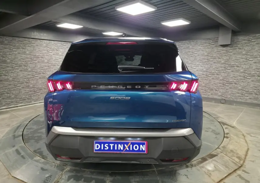 Vue arrière d'un Peugeot 5008 bleu métallisé avec feux arrière LED à 3 griffes et bandeau noir laqué.