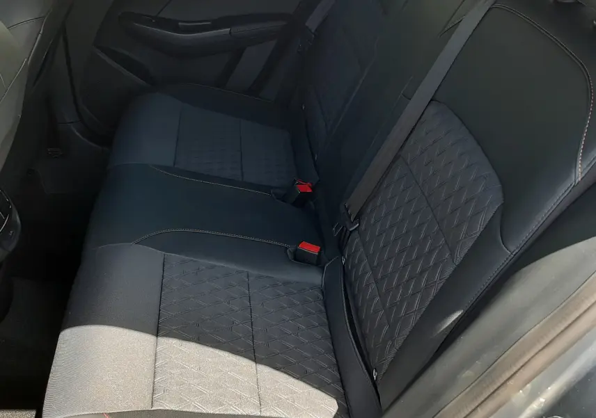 Vue intérieure côté droit des sièges arrière en tissu noir avec surpiqûres orange de la MG3 1.5L Hybrid+ 2026 couleur Hampstead Grey Metal.