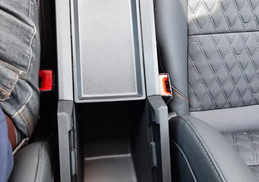 Vue plongeante sur la console centrale ouverte et les sièges noirs à motifs du MG3 1.5L HYBRID+ 195CH LUXURY 2026.
