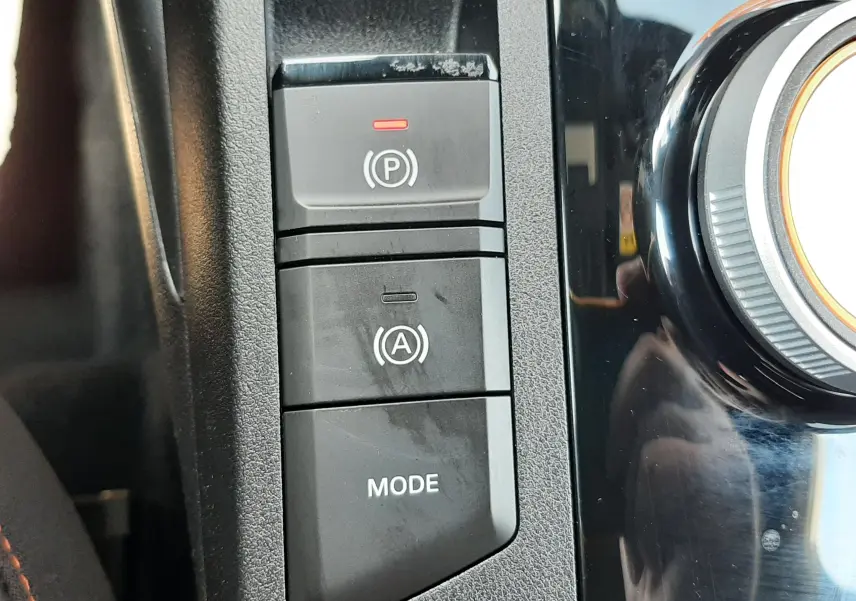 Gros plan sur les commandes de frein à main électronique et mode de conduite dans l’habitacle noir du MG3 1.5L Hybrid+ 2026.