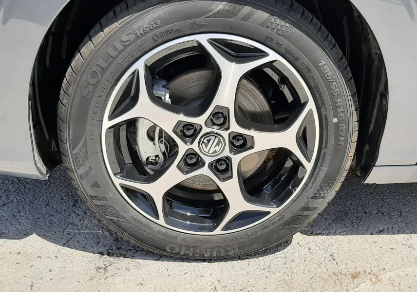Gros plan sur la roue avant droite d’une MG3 1.5L HYBRID+ 195CH Luxury en gris Hampstead avec jante alliage noire et argent.