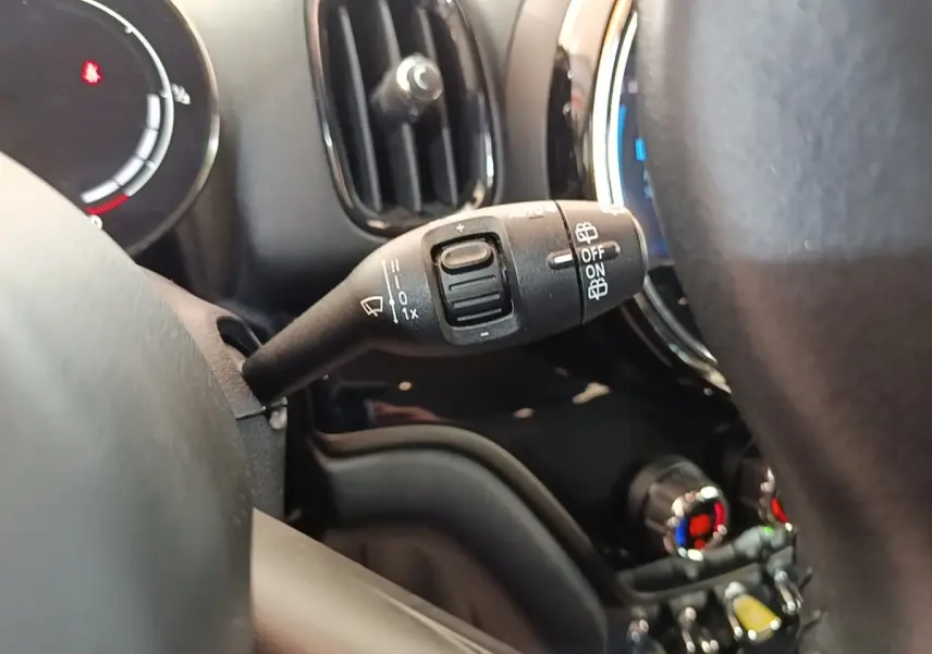 Gros plan sur la commande d’essuie-glace côté gauche du tableau de bord noir du MINI Countryman gris clair hybride rechargeable.