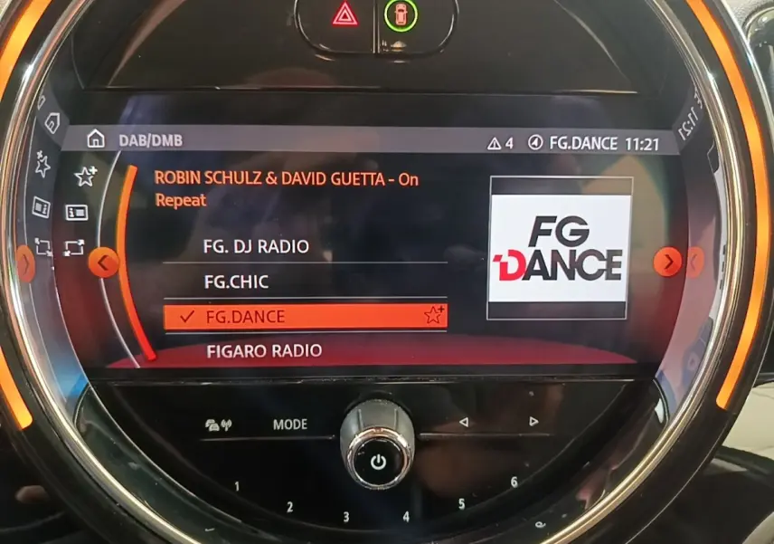 Gros plan sur l’écran tactile central du MINI Countryman gris clair, affichant la radio FG.DANCE en mode DAB.