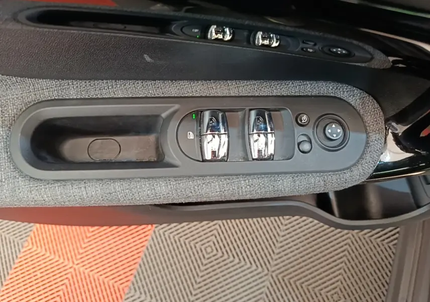 Gros plan sur la commande des vitres et rétroviseurs côté conducteur du MINI Countryman gris clair 2021.