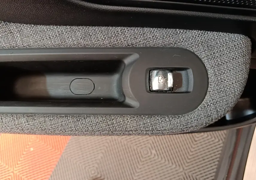 Détail de la commande de verrouillage des portes sur la portière intérieure d’un MINI Countryman gris clair.