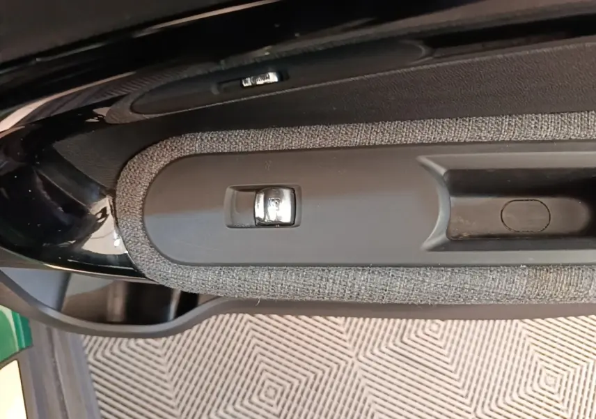 Gros plan sur la poignée intérieure et bouton de verrouillage de porte du MINI Countryman gris clair, vue côté gauche.