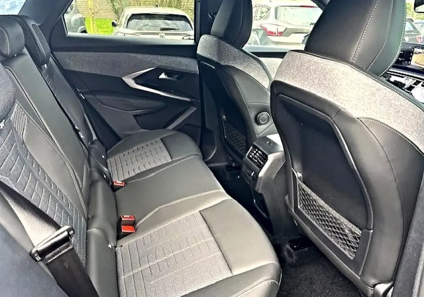 Vue intérieure arrière du Peugeot 3008 gris Artense, montrant les sièges en cuir et tissu avec accoudoirs et aérateurs centraux.