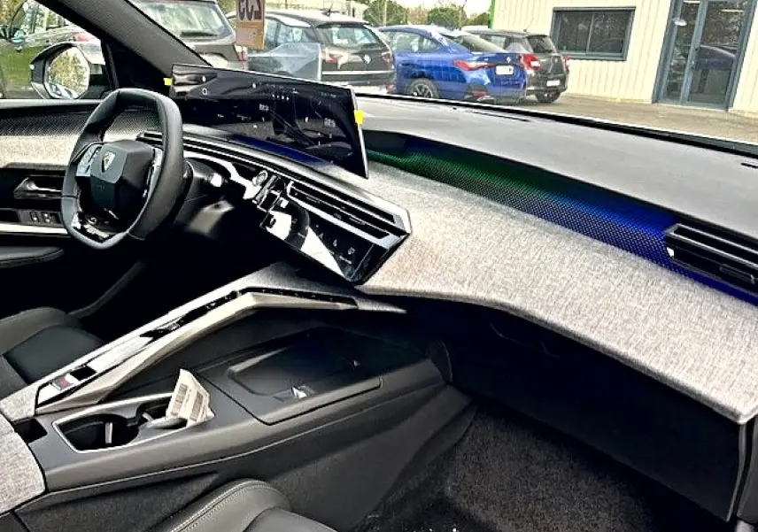 Vue intérieure côté passager du Peugeot 3008 gris Artense 2025, tableau de bord moderne avec écran tactile incurvé.