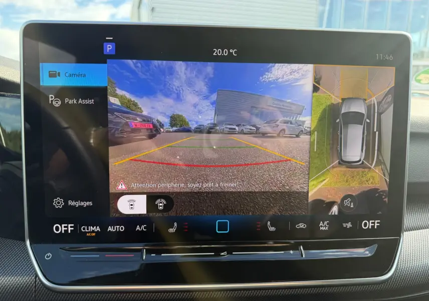 Écran tactile intérieur affichant la caméra de recul et la vue à 360° d'une Volkswagen Golf blanche en stationnement.