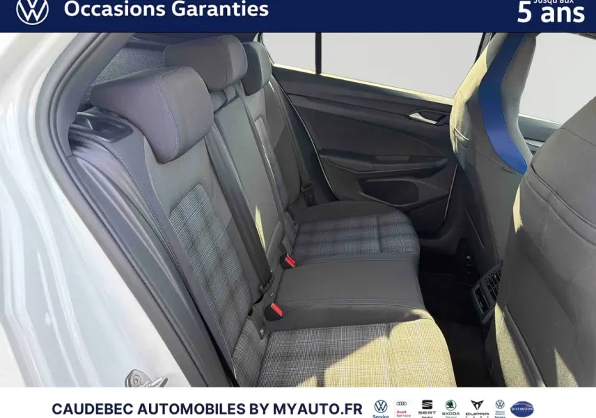 Vue intérieure côté gauche des sièges arrière gris à motifs carreaux d'une Volkswagen Golf blanche, avec détails bleus sur les appuie-têtes.