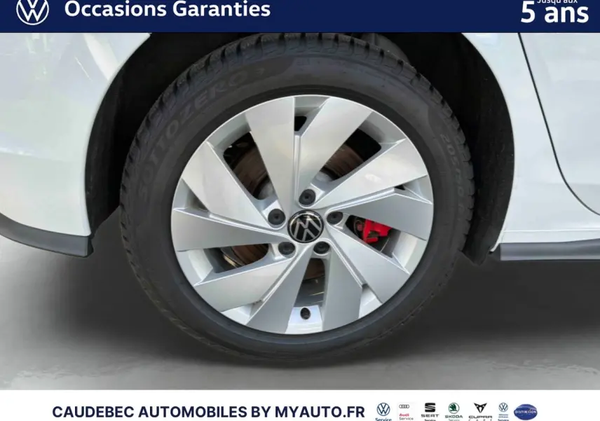 Gros plan sur la roue arrière droite blanche d'une Volkswagen Golf 1.5 eHybrid 2025 avec jante alliage 17 pouces et étrier de frein rouge.