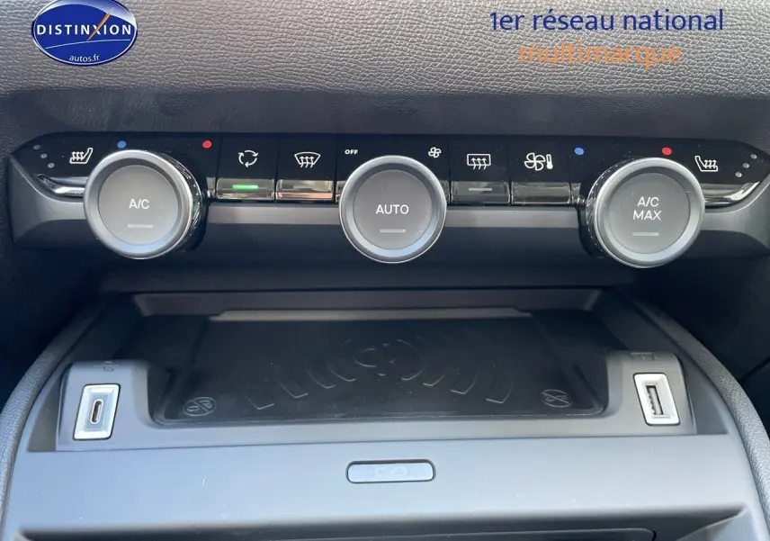 Vue rapprochée de la console centrale de la Citroën C4 2024, montrant les commandes de climatisation et ports USB.
