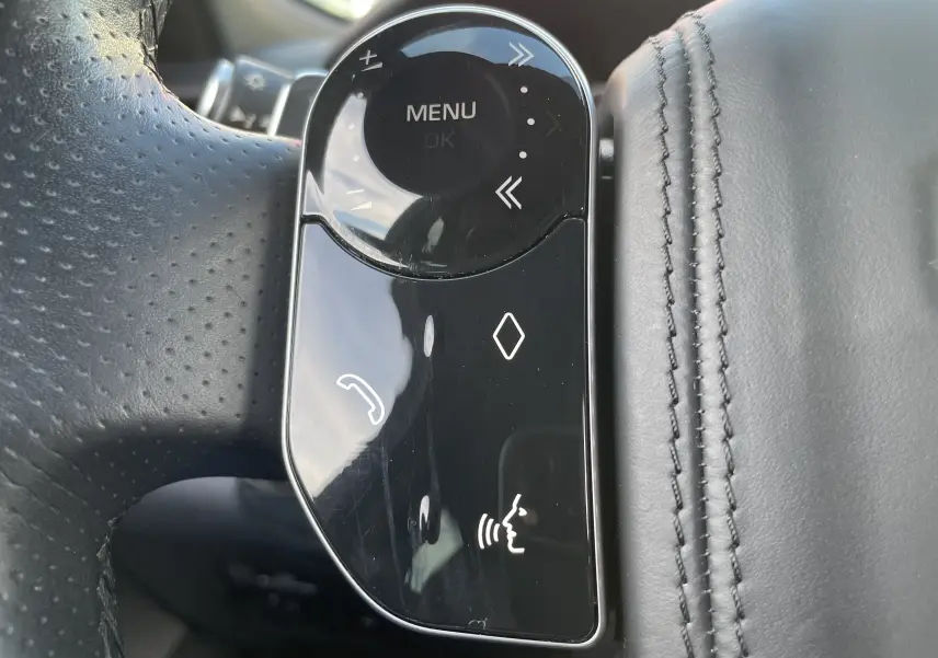 Gros plan sur les commandes tactiles du volant en cuir noir perforé du Range Rover Velar 2019 finition HSE R-Dynamic.