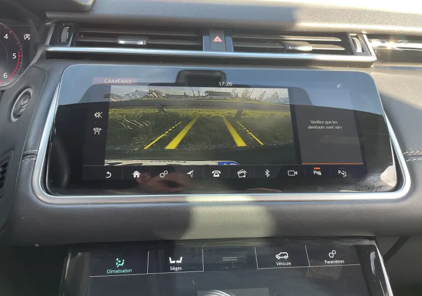 Écran central du Range Rover Velar noir Santorini 2019 montrant la caméra de recul avec lignes de guidage jaunes.